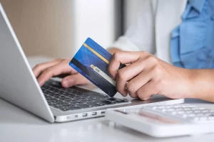 A person holding a bank card to make an online payment.