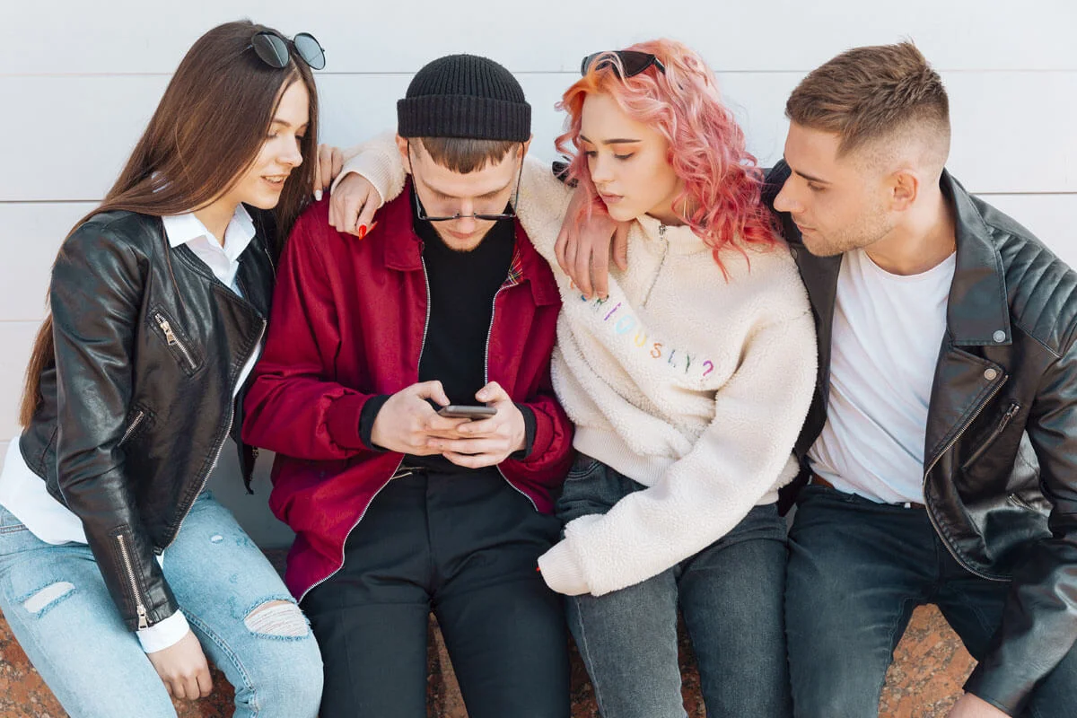 Group of people looking at one of their phones.