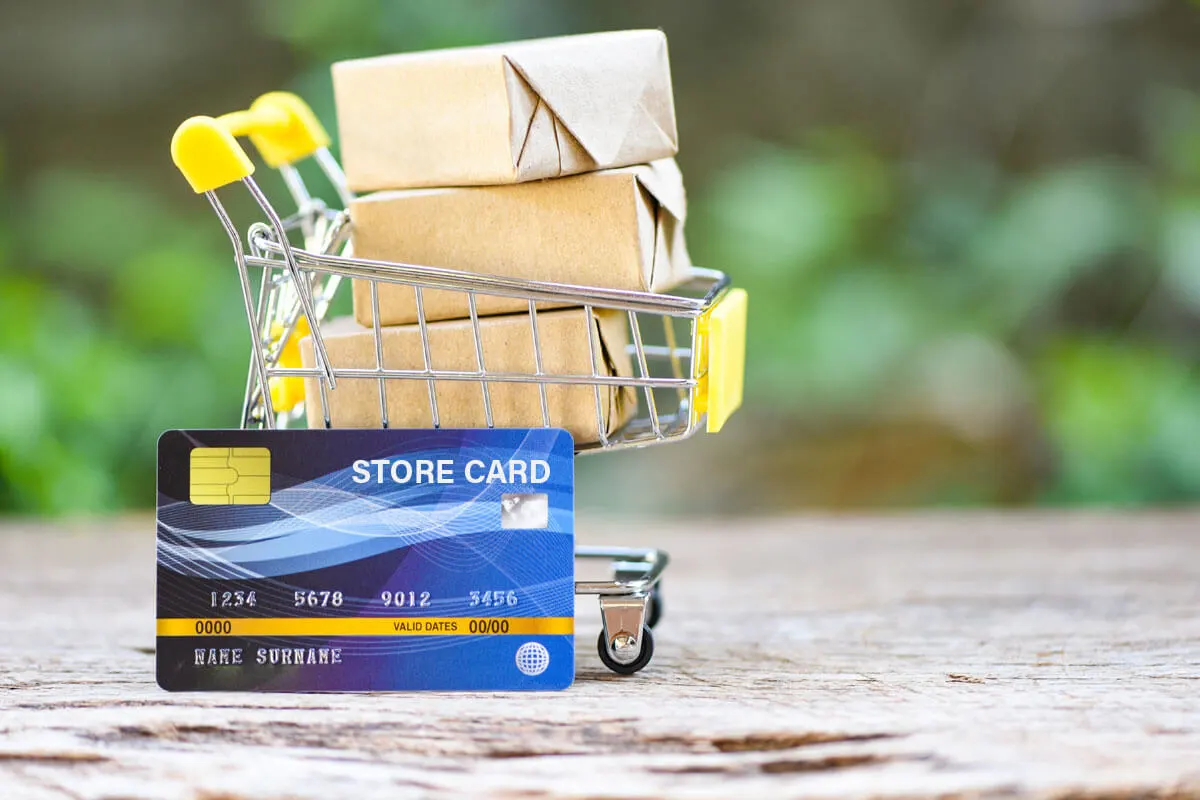 A store card in front of a small shopping trolley.