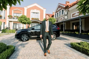 A man in suit walking up a driveway.