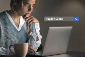 A woman searching for Payday Loans on her laptop.