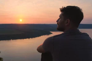 A man sitting outside watching the sunset.